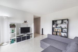 a living room with a couch and a tv at modern flat in Estoril