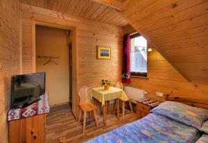 um quarto com uma cama e uma mesa num quarto em Pokoje Gościnne Pod Giewontem em Zakopane