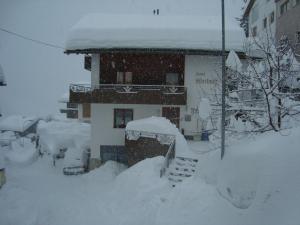 une maison recouverte de neige avec un escalier dans l'établissement Haus Wechner, à Kappl