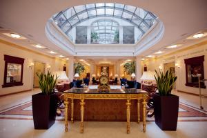 基輔的住宿－Opera Hotel - The Leading Hotels of the World，一个带桌子和玻璃天花板的大型大堂
