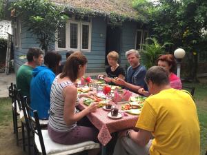 a group of people sitting around a table eating food at Hotel Fishtail Villa in Pokhara