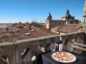 una pizza en una mesa con una botella y vasos en El Altillo, en Ciudad Rodrigo