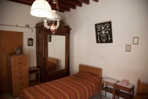 sypialnia z łóżkiem, komodą i lustrem w obiekcie demetrakis house w mieście Pissouri