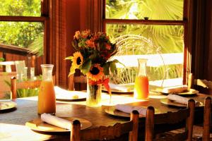 a wooden table with a vase of flowers and orange juice at Cabernet House, an Old World Inn in Napa