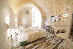 a bedroom with a large bed in a stone building at Sassolino Dimora Storica in Matera
