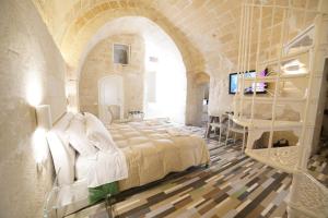 1 dormitorio con 1 cama grande en un edificio de piedra en Sassolino Dimora Storica, en Matera