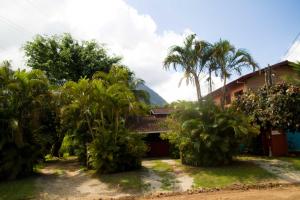 un resort con palme di fronte a un edificio di Chalés Mariah a Ubatuba