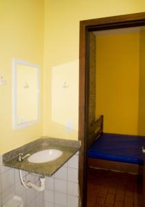 a bathroom with a sink and a blue bed at Chalés Mariah in Ubatuba