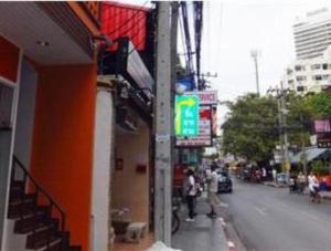 a building on the side of a street with people standing outside at Orchid Inn in Bangkok