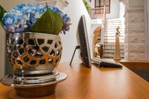 a vase with blue flowers sitting on a desk at Santa Alejandría Hotel in Cartagena de Indias