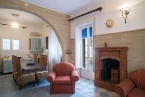 a living room with a fireplace and a table and chairs at Villetta Rossella Mancaversa in Marina di Mancaversa