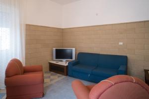 a living room with a blue couch and a tv at Villetta Rossella Mancaversa in Marina di Mancaversa