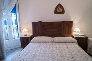 a bedroom with a bed with a wooden headboard at Villetta Rossella Mancaversa in Marina di Mancaversa