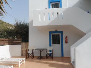 a white house with a blue door and a table at Villa Giorgos in Kefalos