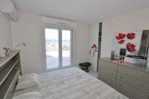 a white bedroom with a bed and a window at Penthouse proche St TROPEZ-Cavalaire in Cavalaire-sur-Mer