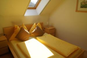 una camera da letto con letto, cuscini e finestra di Riegler`s Buschenschank a Loipersdorf bei Fürstenfeld