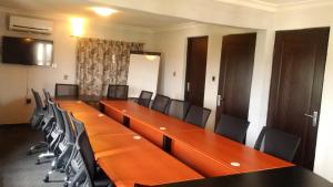 een vergaderzaal met een lange tafel en stoelen bij Villa Nuee Hotel & Suites Utako, Abuja in Abuja