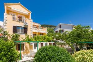 a group of houses on a hill with trees at Apartments Nada in Bol