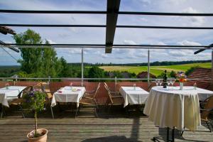 a patio with tables and chairs and a view of a field at Landhotel Traube in Seewald