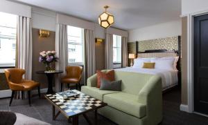 a living room filled with furniture and a large window at The Academy - Small Luxury Hotels of the World in London