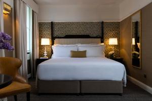 a hotel room with a large bed and two lamps at The Academy - Small Luxury Hotels of the World in London