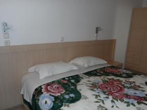 a bed with two pillows and a blanket on it at Villa Giorgos in Kefalos