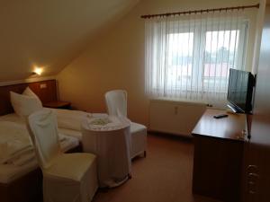 a hotel room with two beds and a television at Weinbau & Pension "8Zeilen" in Golk