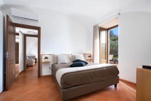 a bedroom with a bed and a large window at Montebosco Luxury Country House in Piano di Sorrento