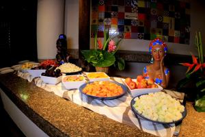 a buffet with bowls of fruit on a counter at Tivoli Ecoresort Praia do Forte in Praia do Forte