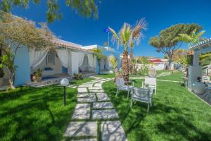 un jardín con mesa y sillas en un patio en Albergo isola mia en Favignana