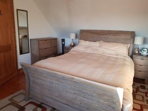 a bedroom with a large bed with a wooden headboard at Seatown Cottage, Lossiemouth in Lossiemouth