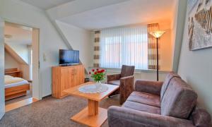 - un salon avec un canapé et une table dans l'établissement Hotel Peters, à Neuharlingersiel