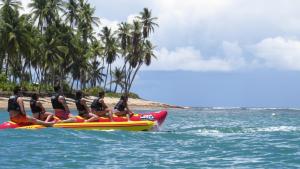 a group of people riding on a paddle board in the ocean at Tivoli Ecoresort Praia do Forte in Praia do Forte