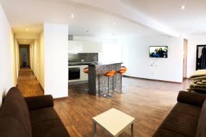 ein Wohnzimmer und eine Küche mit einem Sofa und einem Tisch in der Unterkunft Teniente Aguado in Alicante