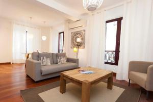 Una sala de estar con un sofá y una mesa de café. en La Casa de la Alameda, en Málaga
