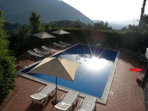 a swimming pool with umbrellas and chairs and a swimming poolvisor at Lady Food Location in Cava deʼ Tirreni
