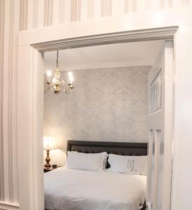 a bedroom with a white bed and a chandelier at Hawthorne Hotel in Salem