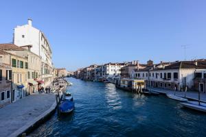 uma vista para um canal com edifícios e barcos em Rousseau's Apartment em Veneza