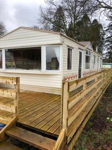 a tiny house on a deck with a fence at 35 Glenfinart Park in Dunoon