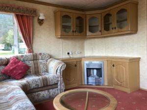 a living room with a couch and a fireplace at 35 Glenfinart Park in Dunoon