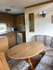a kitchen with a wooden table and two couches in a room at 35 Glenfinart Park in Dunoon