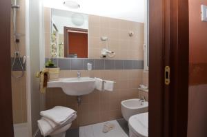 a bathroom with a sink and a toilet and a mirror at Hotel Genova in La Spezia +34 photos