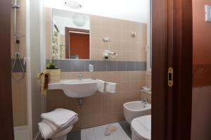 ラ・スペツィアにあるホテル ジェノバのバスルーム(洗面台、トイレ、鏡付)