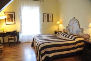 a bedroom with a bed and a desk and a window at Relais Casabella in Martina Franca