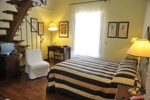 a bedroom with a bed and a staircase with a window at Relais Casabella in Martina Franca