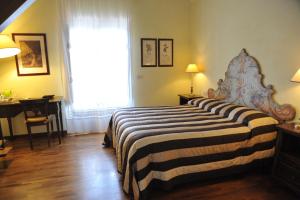 a bedroom with a bed and a desk and a window at Relais Casabella in Martina Franca