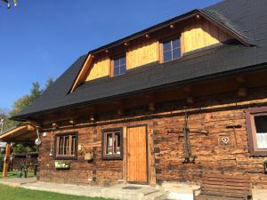 a log cabin with a black roof and a door at Drevenička 110 in Zázrivá