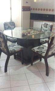 una mesa de cristal con 2 sillas y una mesa de cristal con en Apartamento para locação - cód 34, en Bombinhas