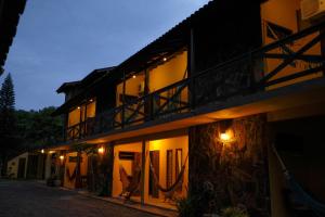 a building with a balcony on the side at night at Pousada Beira Mar in Garopaba