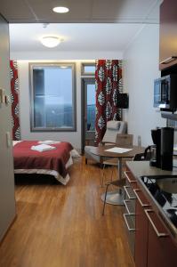 Aparthotel Simpsiönkullas في لابوا: غرفة صغيرة مع سرير ومطبخ مع مطبخ gmxwell gmaxwell
